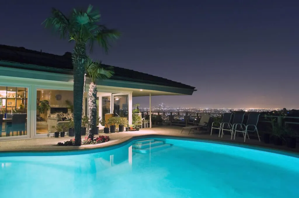 5 Benefits of Building an In-Ground Pool 3 backyard pool installed by professional pool builder overlooking cityscape at night