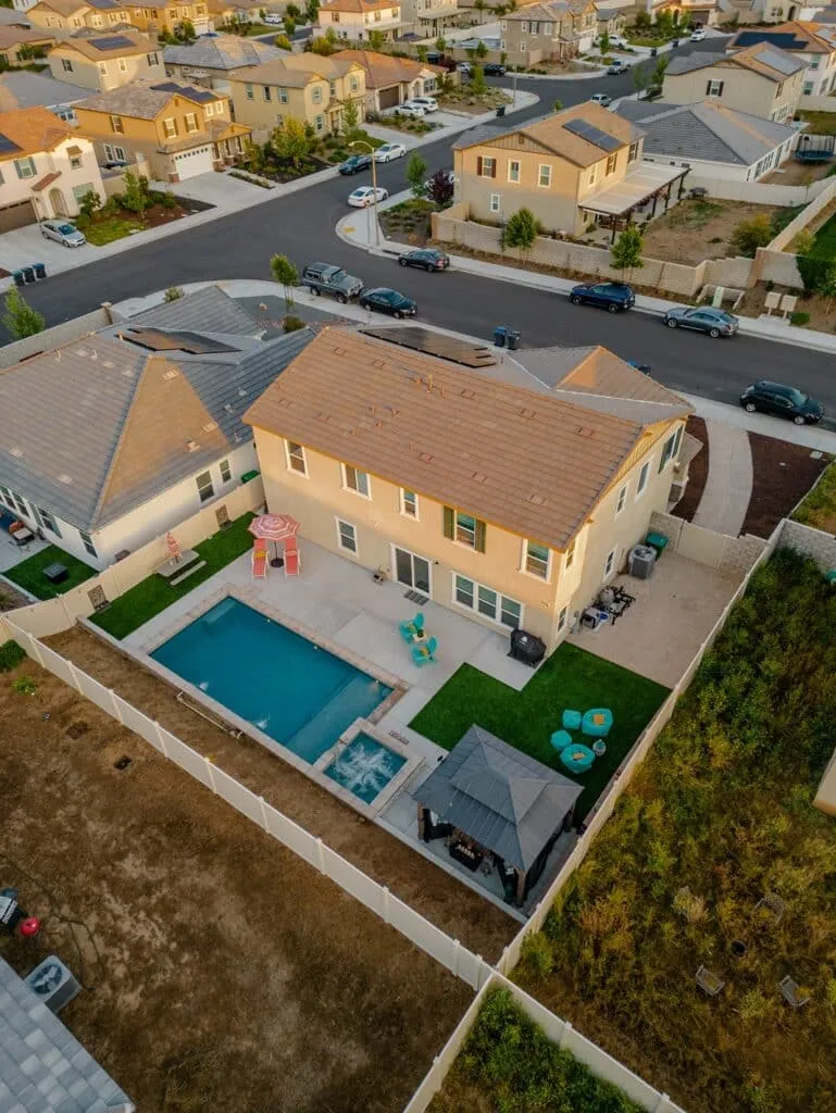 Modern residential backyard pool with patio and outdoor seating, showcasing quality pool construction for homeowners researching pool builders in Corona, CA.