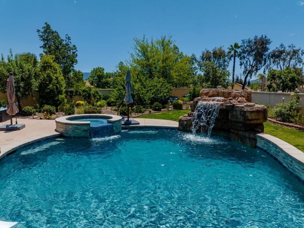 Custom backyard pool with a hot tub