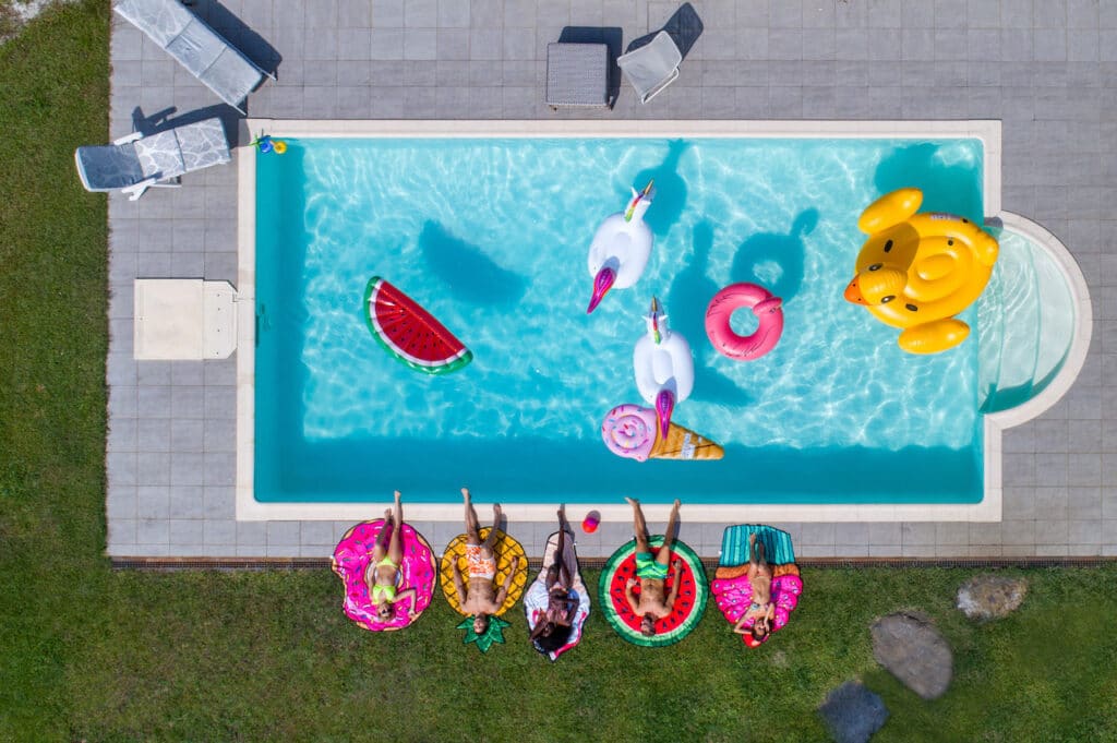 aerial view of friends with pool floats relaxing poolside