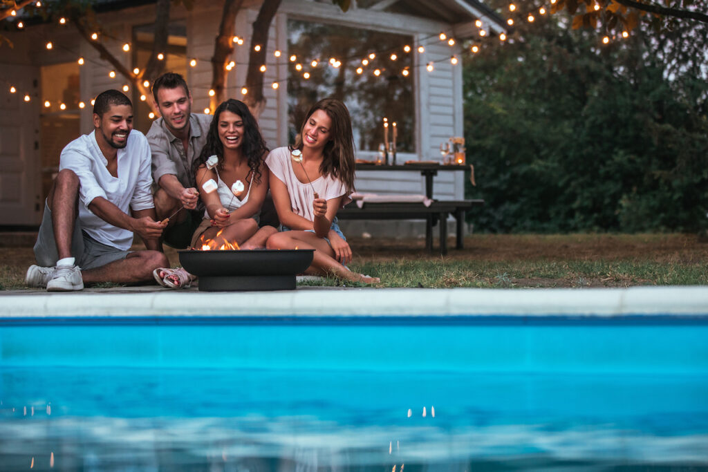 friends roasting marshmallows near the pool