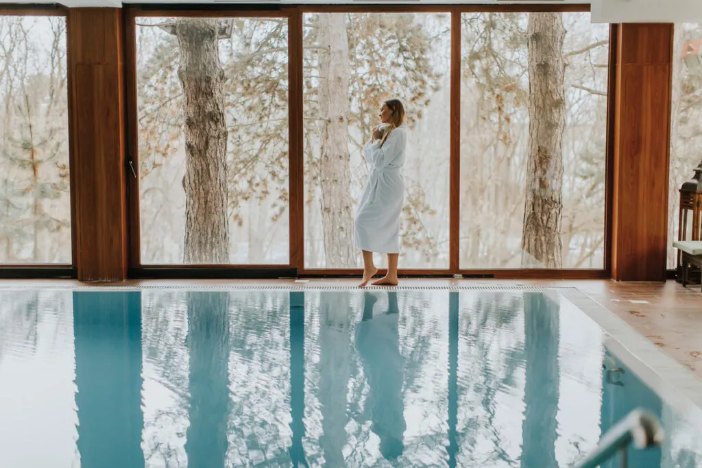 Women walking by a pool that's next to a window