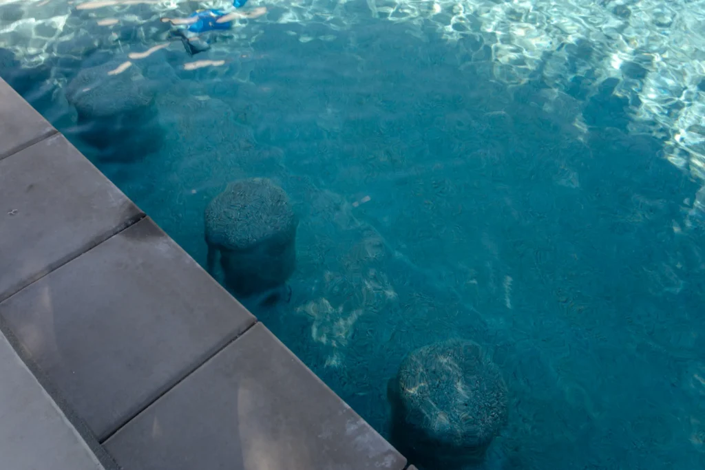 Swimming pool with submerged spa seating, highlighting an energy-efficient residential pool system affected by California’s updated pool heater regulations