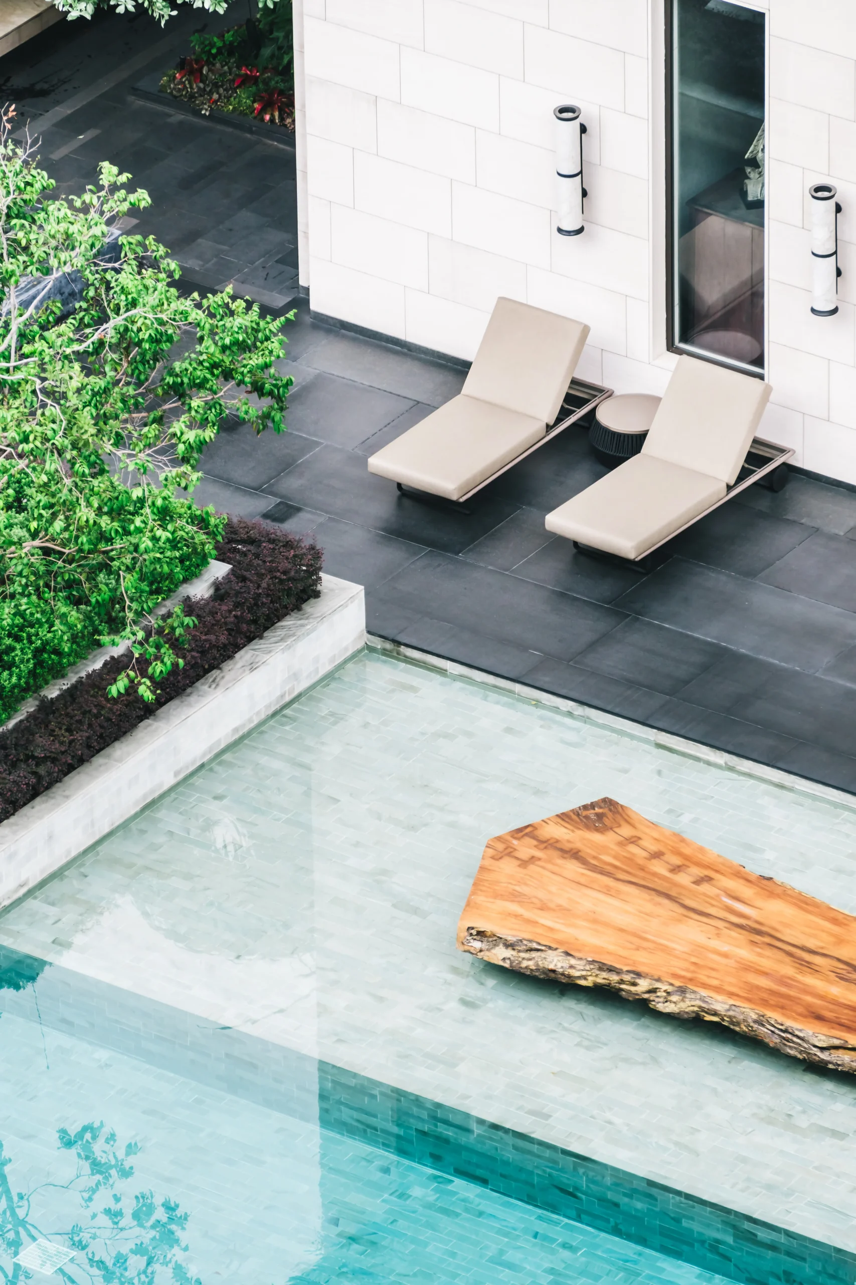 Luxury swimming pool with custom design, lounge chairs, and modern landscaping tailored by expert pool builders