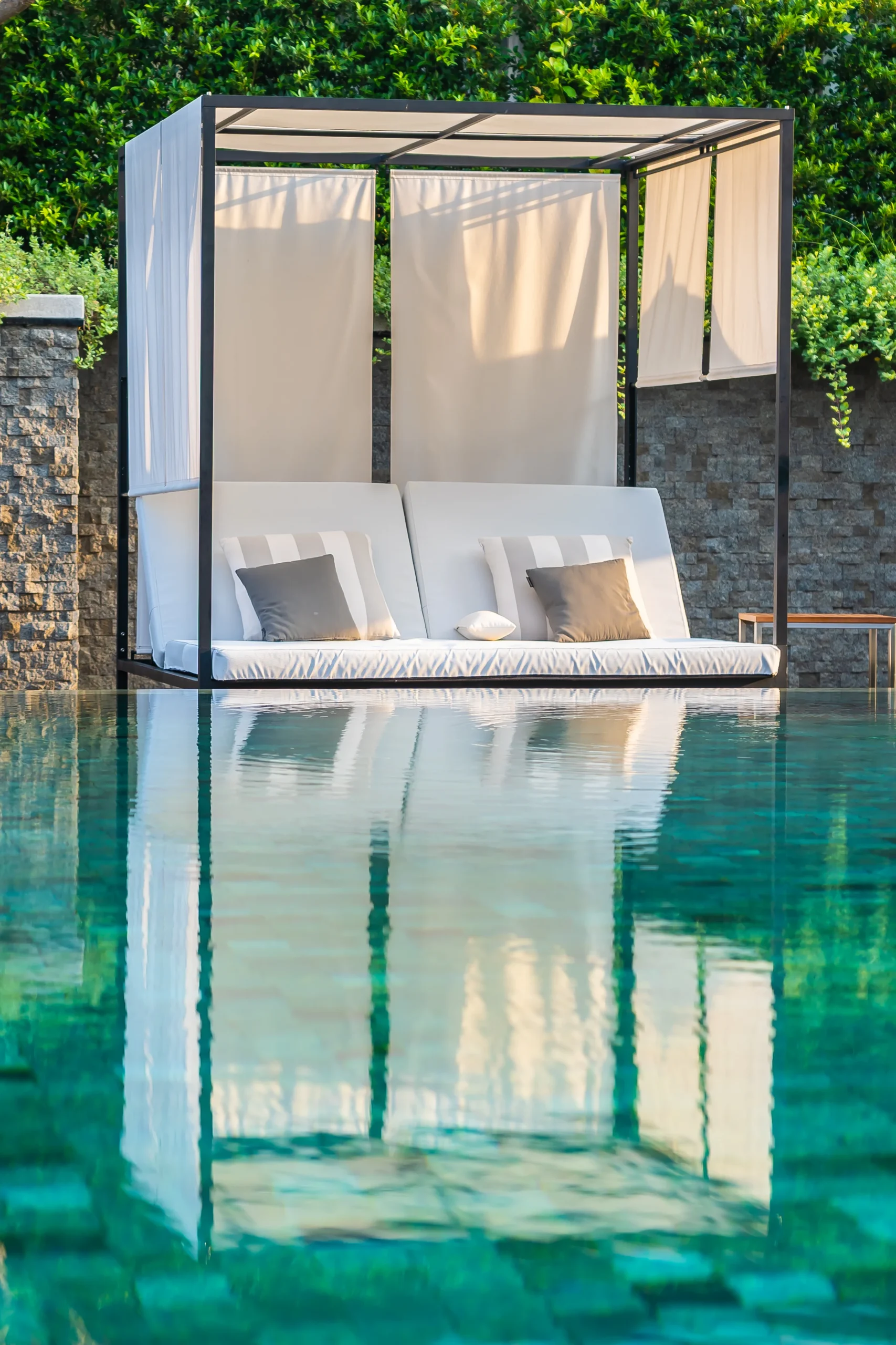 Pool Builder Serving Southern California and Southern Utah 9 Luxury outdoor pool cabana with cushioned lounge seating beside a modern swimming pool in Southern Utah